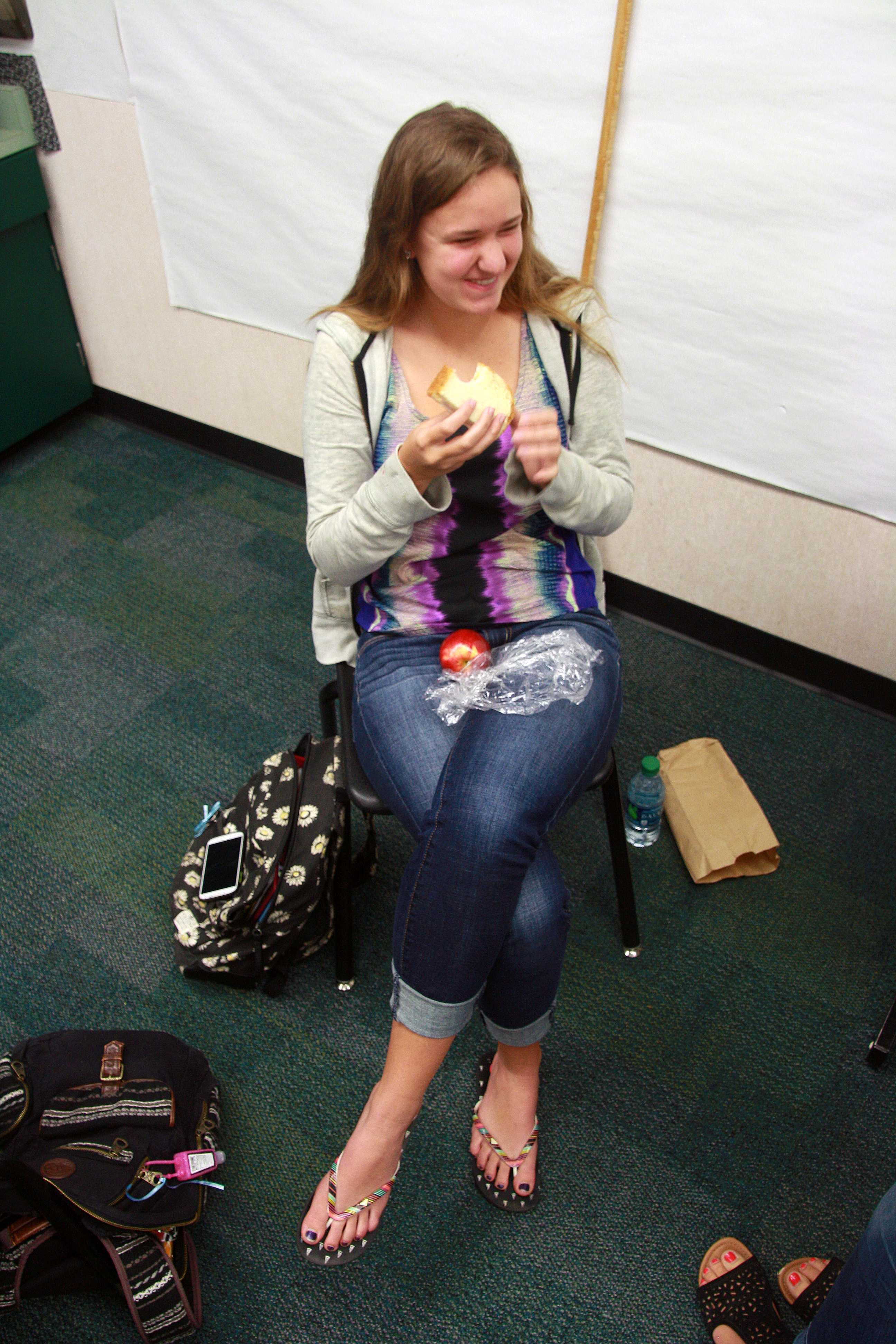 To avoid dropping her sandwich junior Erin Cline contains her laughter during lunch on April16. Her friends were in a debate over if peanut butter is better than Nutella and the conversation got a little too heated. Cline thought the conversation was ridiculous and very random so she found it funny. "It's sometimes hard to eat your whole lunch during lunch because you are trying to catch up with your friends. Also on other times my friends come up with the most random and humorous dialogues and then I still won't finish my lunch because I'm cracking up with laughter," Cline said. Photo by Ambreen Siddiqui