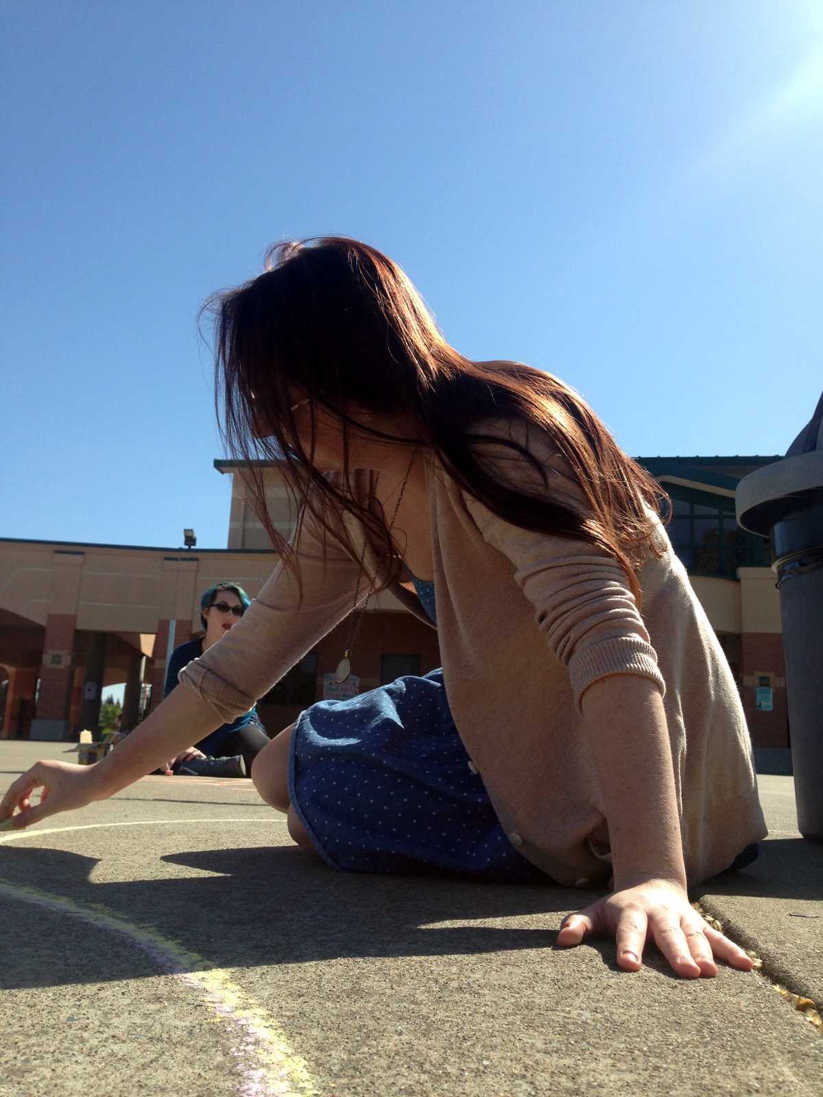 To bring awareness to the Day of Silence, GSA co-vice president Delaney Crabtree writes in chalk on the quad sidewalks giving information trying to get others to participate. The GSA handed out papers for students to wear around their necks giving information to others as to why they aren’t speaking on April 17. “I joined GSA because it’s an opportunity to be apart of a group that is incredibly accepting and welcoming, as well as incredibly active when it comes to making changes on campus to better the LGBT community.” Crabtree said. Photo by Kristen Goldman