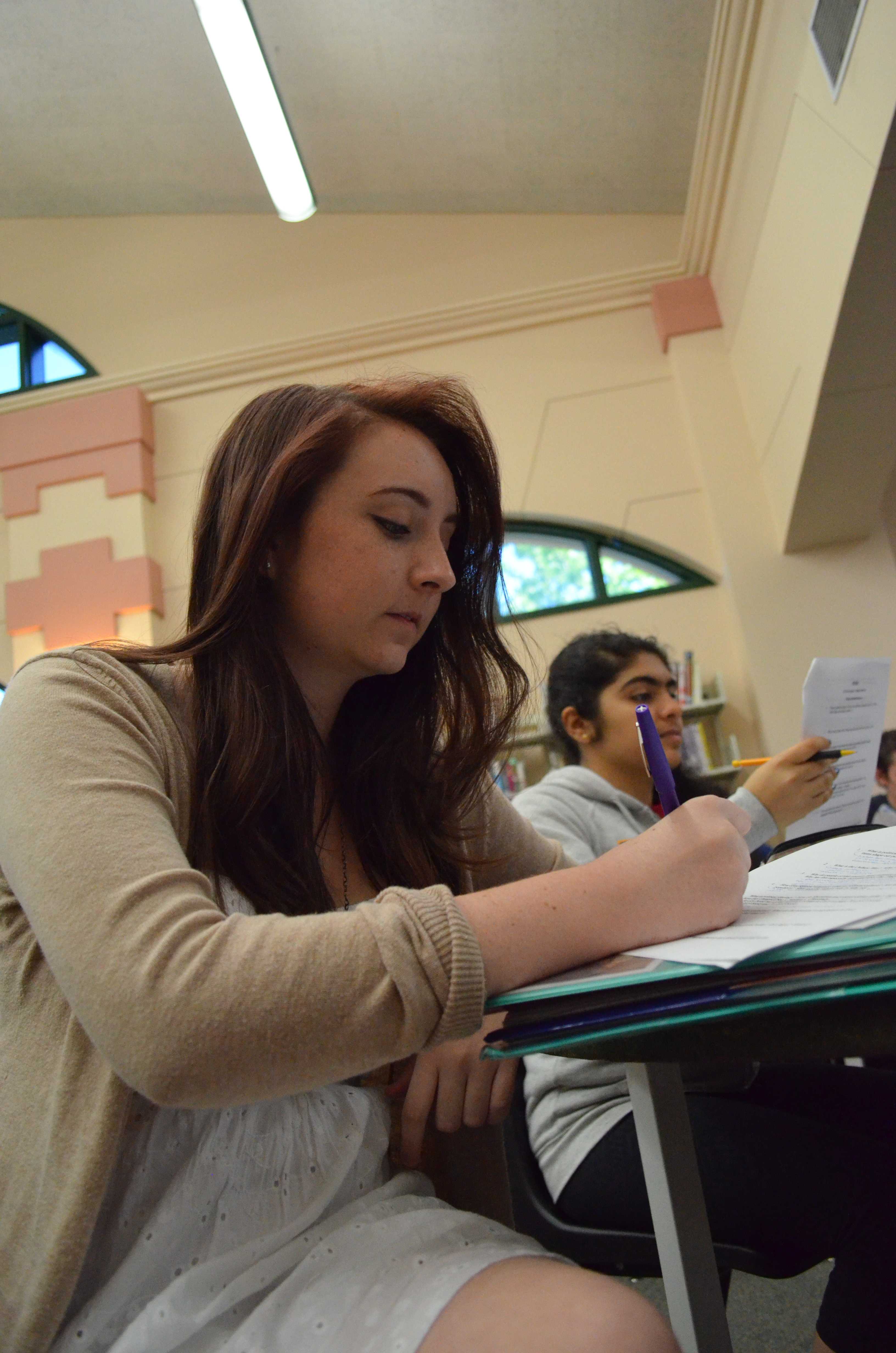 At the second AP Government study session, senior Delaney Crabtree writes notes as government teacher, Jarrod Westberg, recaps every unit since the beginning of the year. Hour long study sessions were provided for every student that had taken or were currently taking the AP Government course. “I like the study sessions because it allows students to, in a way, re learn what they might have forgotten. For me, I am in the AP Government block class, so the sessions refresh my memory from units that I learned way at the beginning of the year,” Crabtree said. Photo by Michaelan George