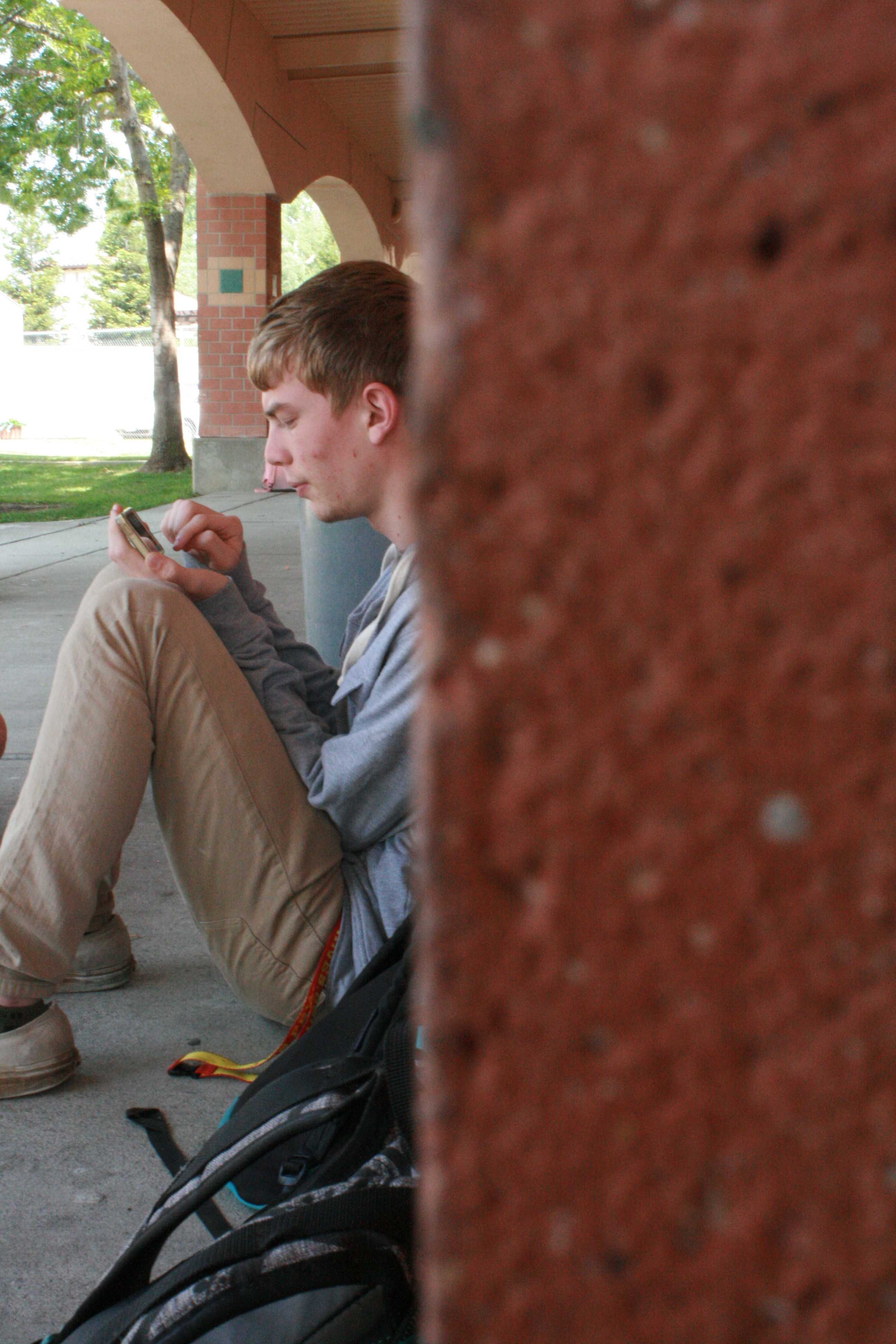 NEXT LEVEL GAMERS: Although senior Drew Dyson is at lunch he plays a new iphone game “Hearthstone”, battling his younger brother Freshmen Anthony Dyson. The Dyson brothers and freshmen Dillon Wilder talk about and play this new Phone game expanding from a popular computer game ‘World Of Warcraft’. “I really like playing this game its fun and exciting its a strategy based game but its also about luck and pulling good cards, the game can go anyway which makes it really fun to play especially going up against my brother and friends”,Dyson said. Photo by Dillon Wilder