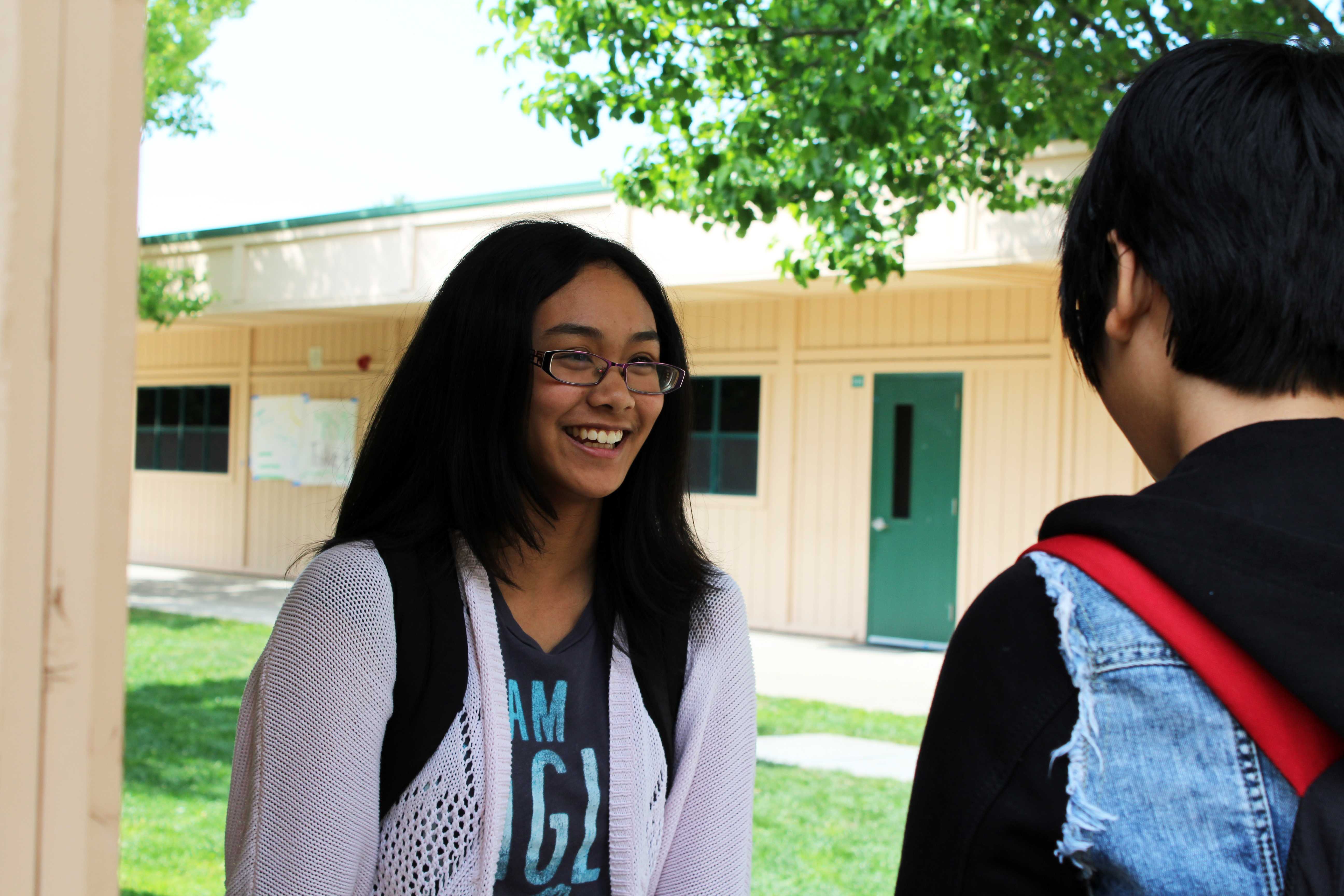 CHIT CHAT: Although freshmen Carissa dela Cruz and Amy Hung had to leave soon, they waited and talked to each other before their rides showed up. “Taking the time to catch up with friends is important and laughing together makes the day better,” dela Cruz said. After talking about the English book they were reading in class, the two friends split up and went home. Photo by Lindsay Withrow