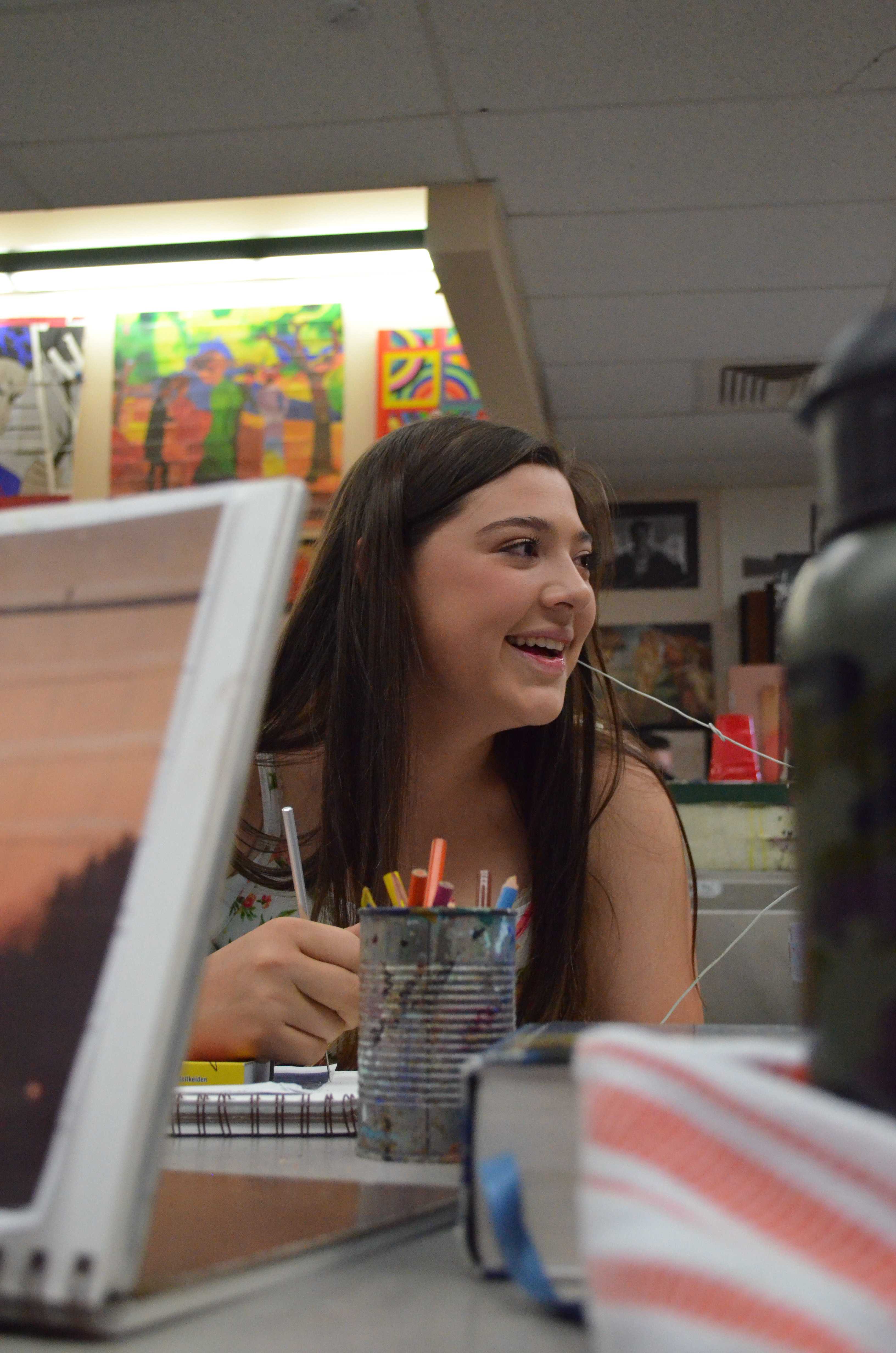 LAUGH IT OFF: If freshman Paige Waid hadn’t taken a break from her art project, then she would have missed the joke her table mates made. Brad Cordell’s Art 1 class was working on pastel projects for the past couple of weeks. “I liked the graphite project more than this pastel project. With graphite I was able to fit more detail into my picture”, Waid said. Photo by Michaelan George