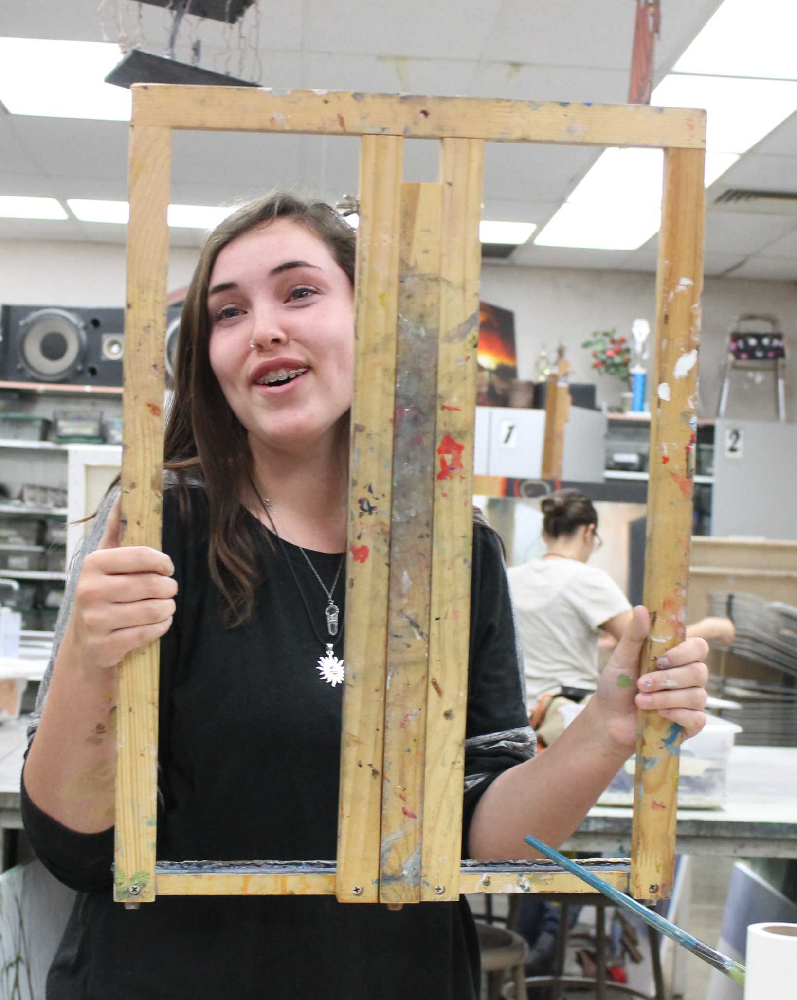 EFFICIENT EXCELLENCE: Although the paint still drips on the table, junior Jennah Qunell starts to put away one of the portable canvases in Mr. Stephens's art class on April 21. Qunell took the extra time to scrape the paint off the table because as she painted rocks, she used a lot of paint." Cleaning up takes forever because even when you think you are done, you end up with paint on every article of clothing you are wearing at the moment," Qunell said. Photo by Ambreen Siddiqui