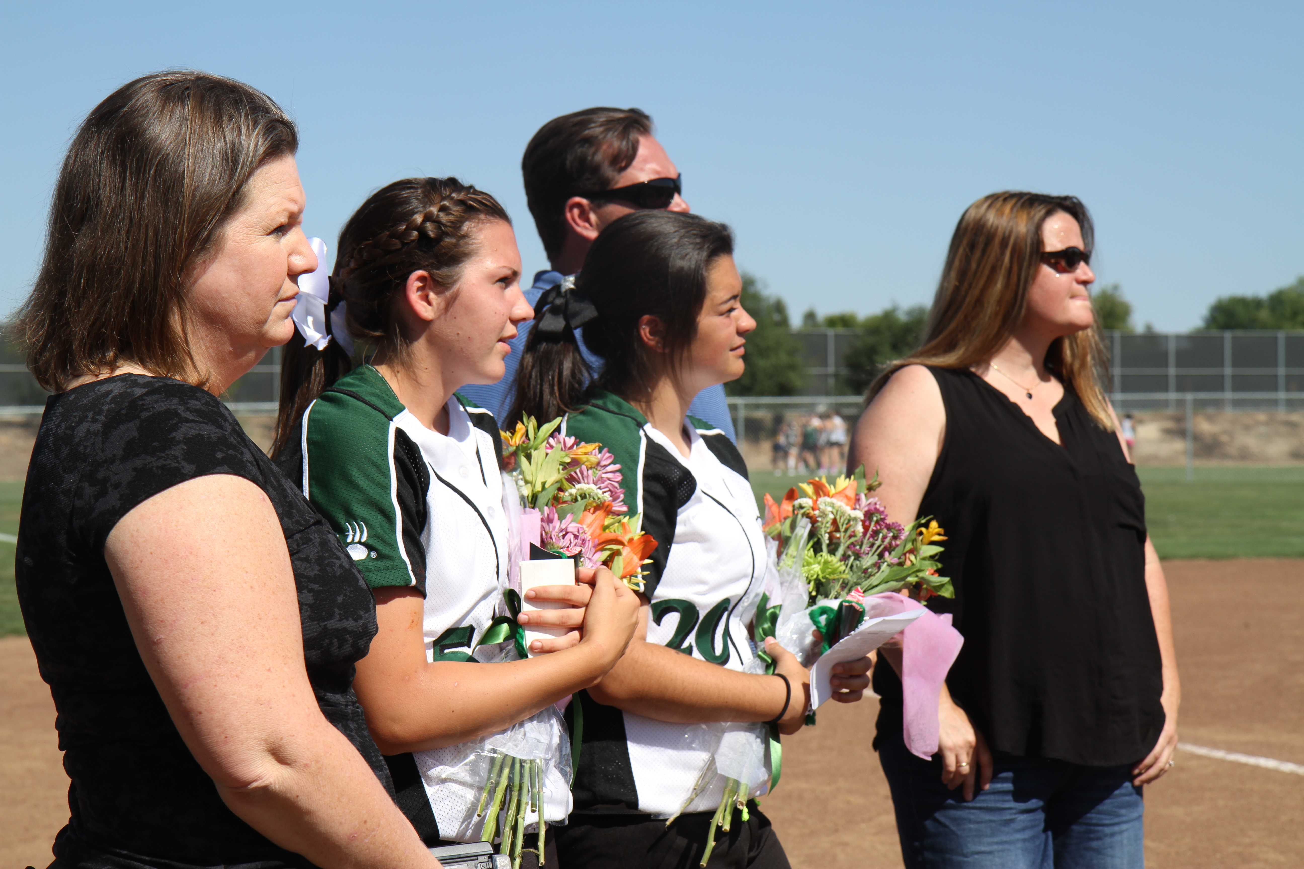 LAST GAME Because it’s the seniors’ last home softball game, seniors Ashleigh Berg and Ashley Martin receive flowers and a special speech from their coaches. The seniors’ parents and grandparents come to support the lady grizzlies at their last home game. For the underclassmen on the team along with the coaches, it was a very emotional experience. “Watching this happen to the previous seniors when we were juniors/underclassmen  was always sad, but now that we are seniors going through this it’s even more sad because I’ve been with these coaches for the past three years,” Berg said. Photo by Janelle Cruz
